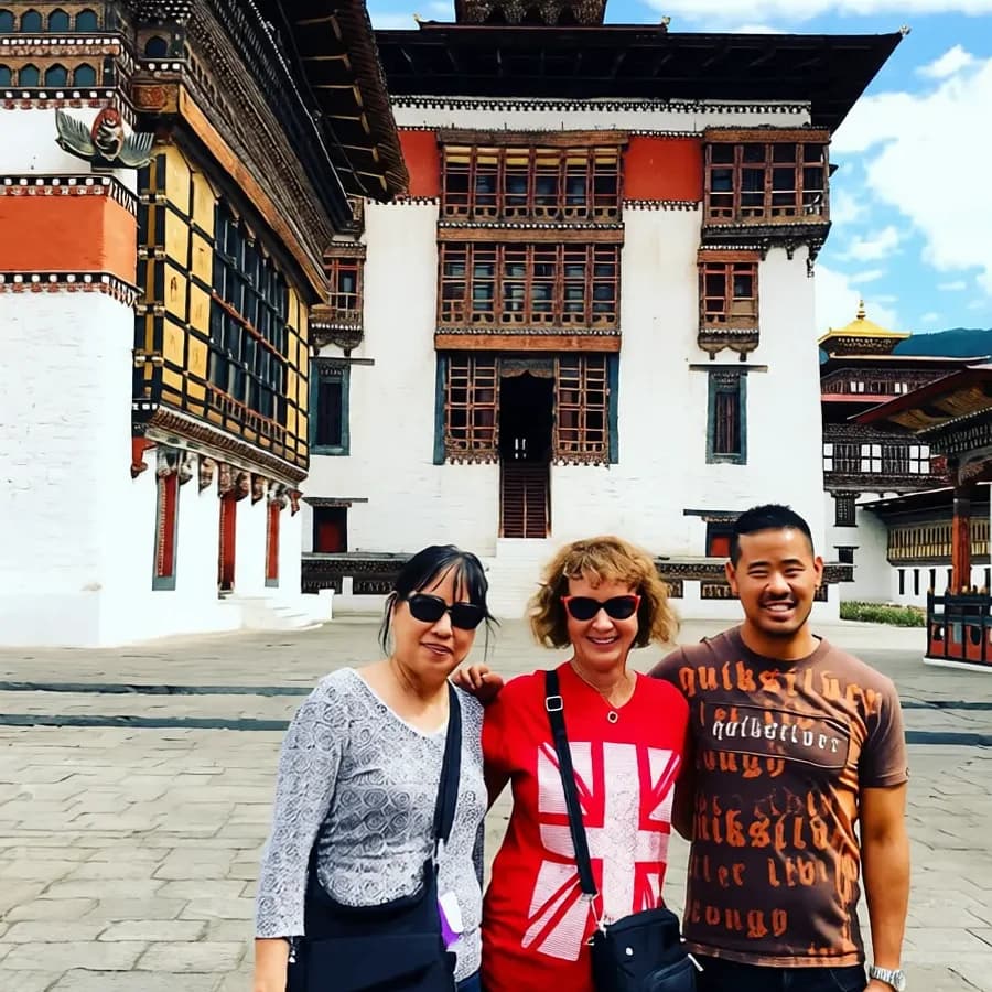 Three travelers standing in front of a Bhutanese dzong