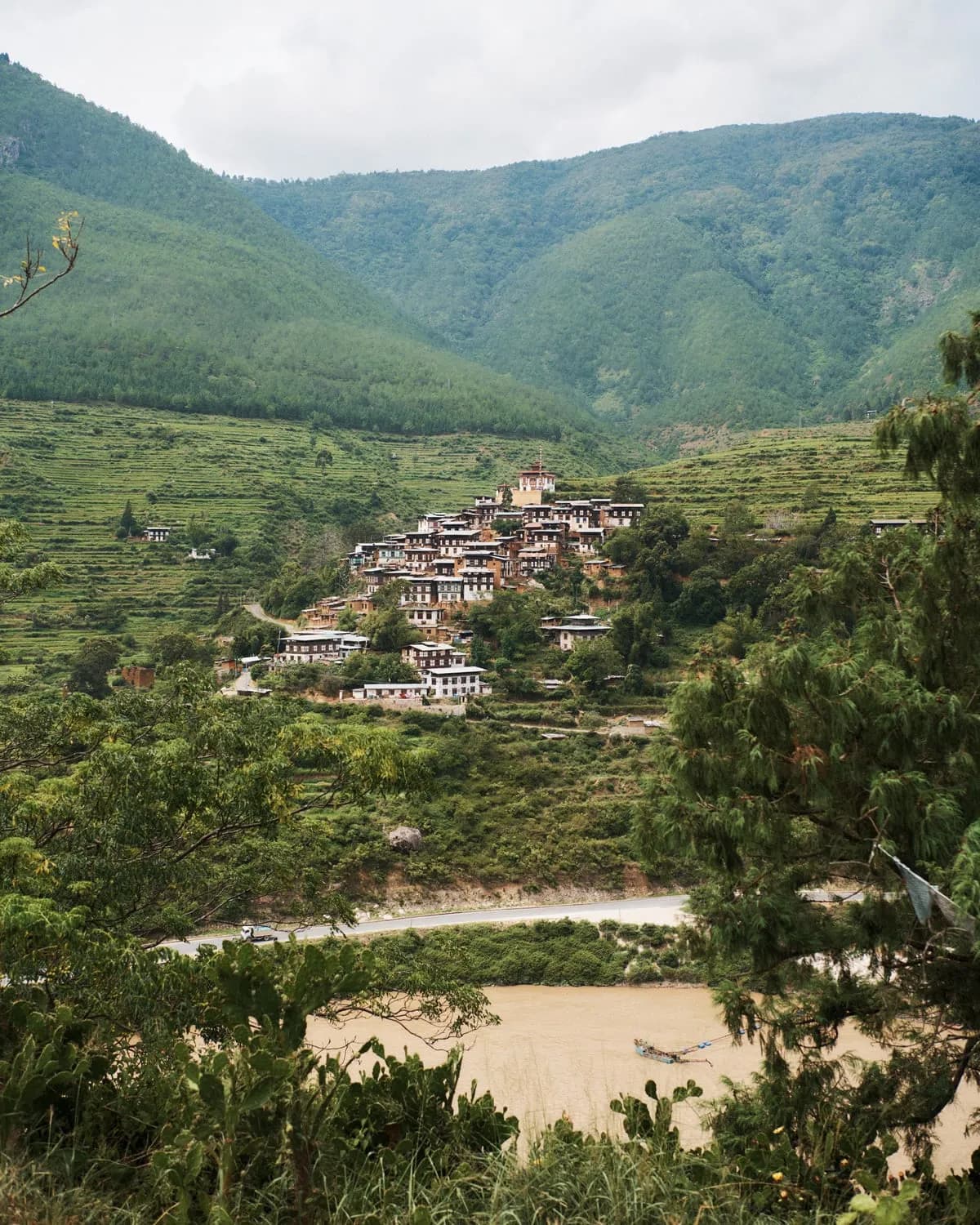 Traditional Bhutanese village on a hillside above a river in Haa Valley