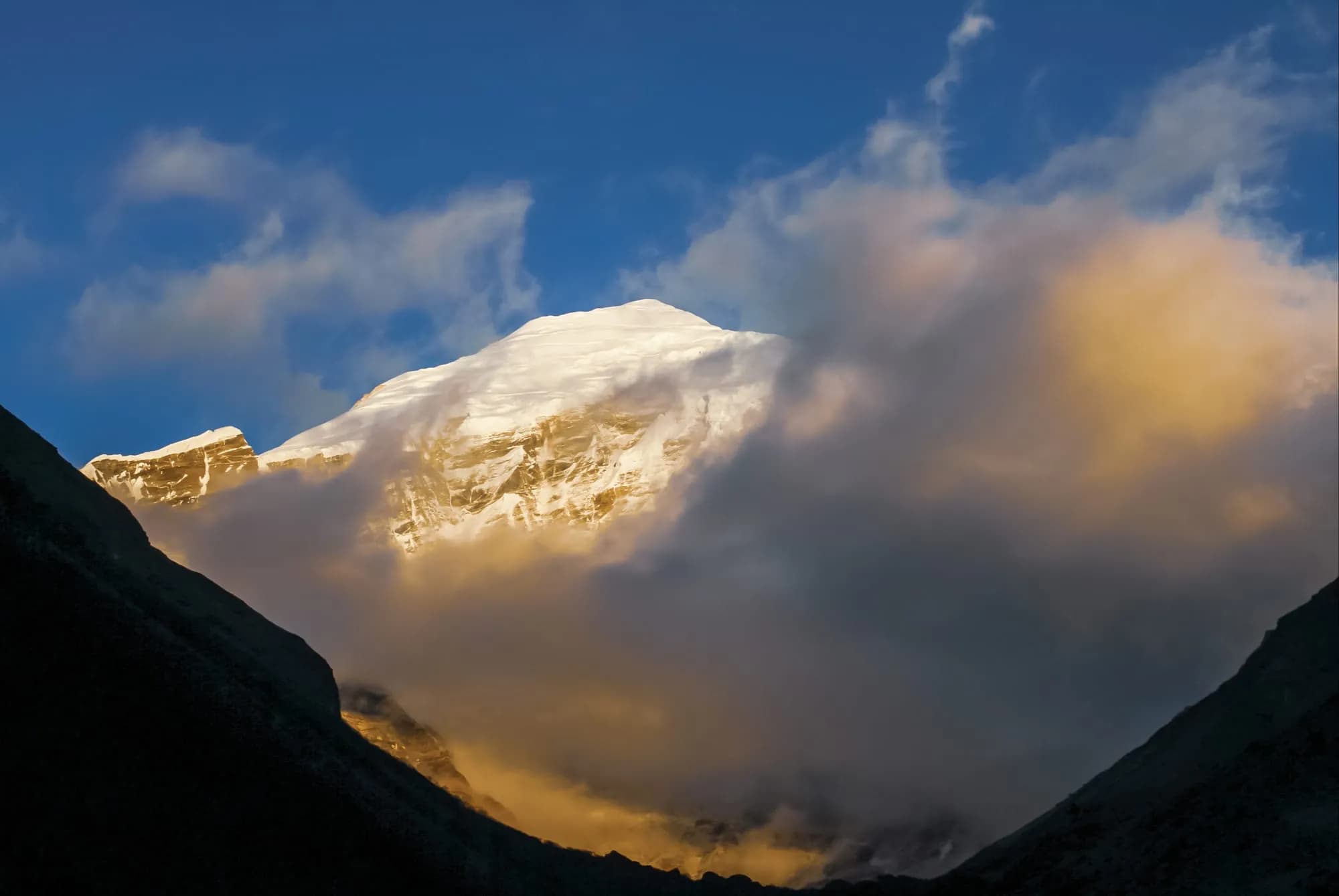 Sunlit Himalayan peak above the clouds