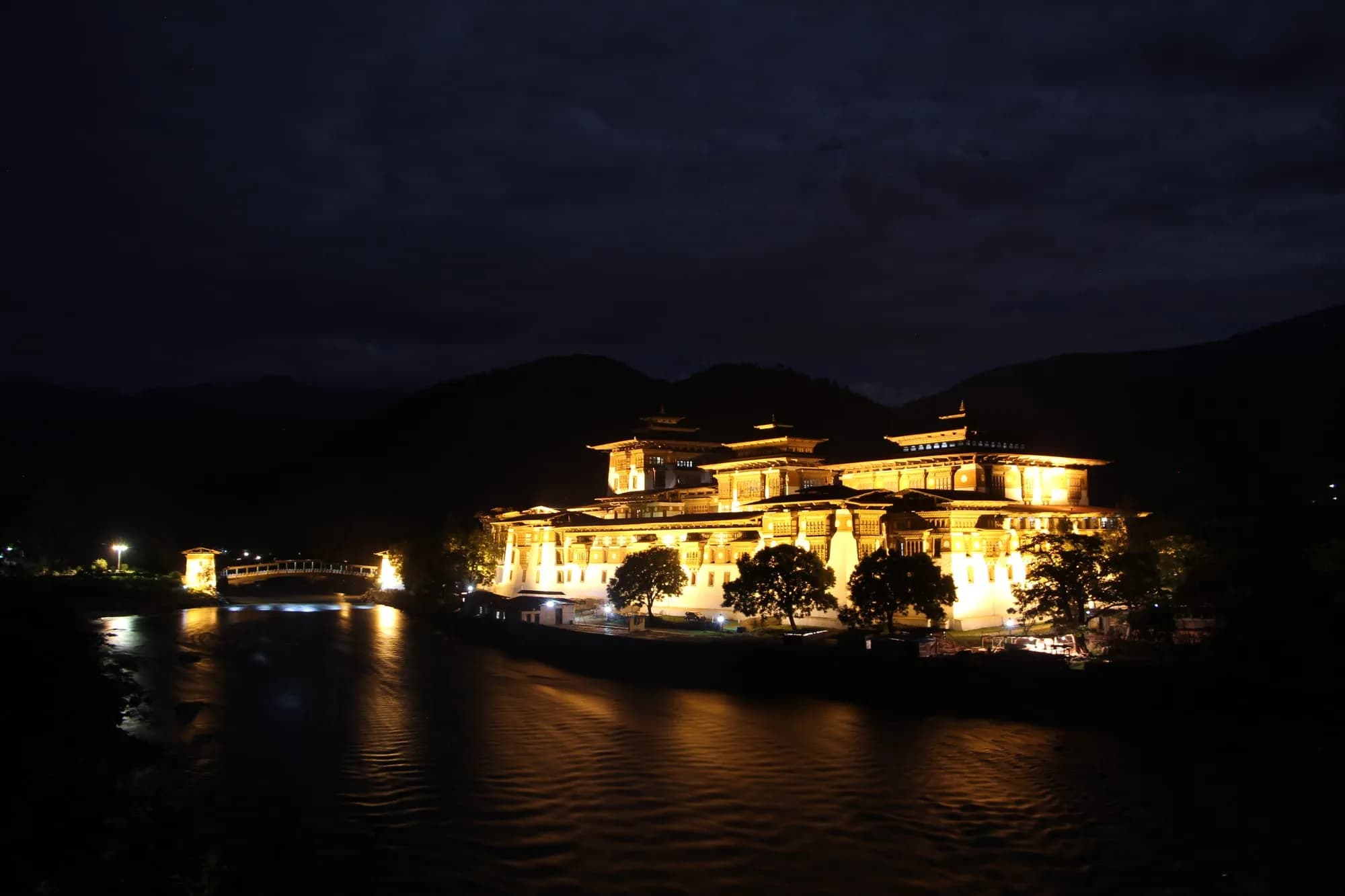 Punakha Dzong illuminated at night beside the river